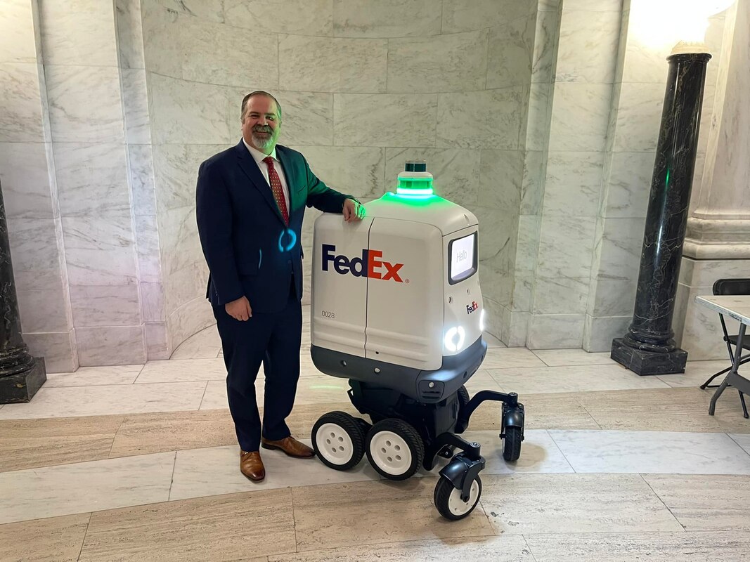 Picture of Delegate Clay Riley with a Fed-Ex Delivery Bot at the WV State Capitol